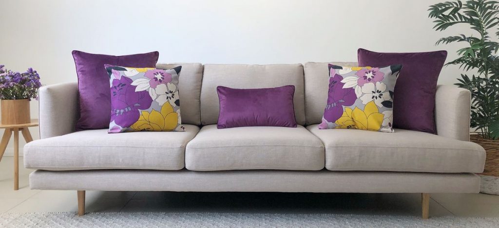 https://www.simplycushions.com.au/wp-content/uploads/2013/11/Grey-sofa-with-purple-and-yellow-cushion-arrangement-1024x469.jpg