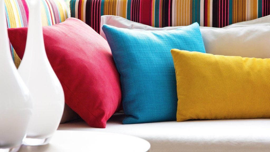 Colourful cushions alongside some vases