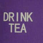 Close up of linen purple cushion with drink tea written on it