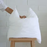 A hand is pressing into a 45x45 cushion insert.