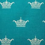 Close up of crown pattern in teal on cushion cover