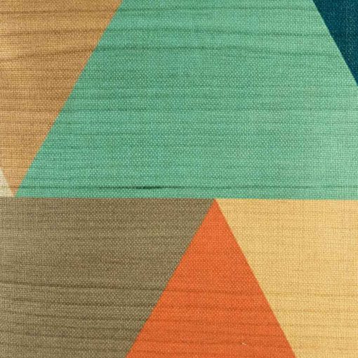 Close up of cushion featuring large triangles in teal and orange