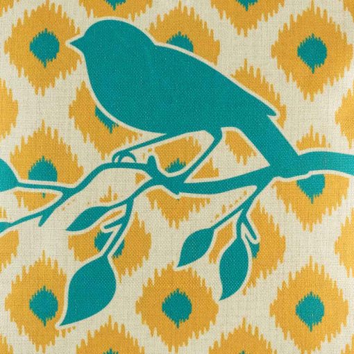 Close up showing bird sitting on branch on cushion cover