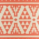 Close up view of orange and red cushion cover with contemporary design