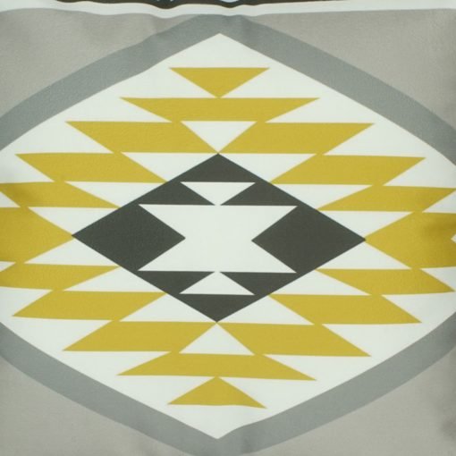 Close up of yellow, grey and white velvet cushion with Aztec print
