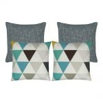 A set of four square cushions in teal and grey colours and triangle patterns