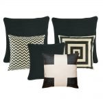 A set of black and white cushions with square, chevron and cross patterns