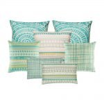 A set of seven teal and white square cushion covers with linear, abstract and triangle designs
