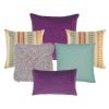 A collection of plum, lilac, teal and multi-colored cushions in square and rectangular shapes