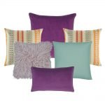 A collection of plum, lilac, teal and multi-colored cushions in square and rectangular shapes