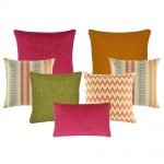 A mix of rectangular and square cushions with orange, green and fuchsia colours in solid, chevron and stripe designs