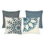 A mix of four square blue and grey cushions with snowflake patterns