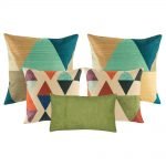 A mix of square and rectangular cushions with diamond and triangle patterns with tones of green blue teal and brown