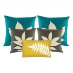 A collection of 5 cushions in teal, grey and yellow colours with leaf patterns