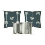 A photo of three cushion covers with arrow and stripes design, in white and grey colours