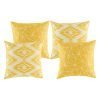 A collection of 4 square gold yellow cushions in geometric, modern patterns
