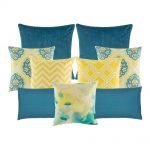 A mix of square and rectangular cushions with blue and yellow colours and diamond and zigzag patterns
