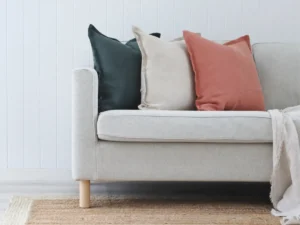 A collection of block coloured linen cushions on a sofa.