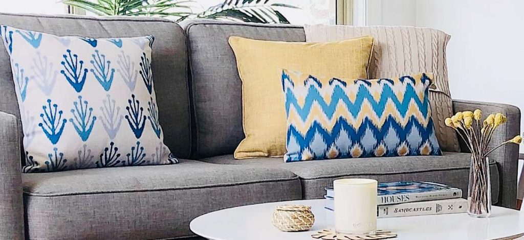 A coastal scene room with blue and yellow cushions