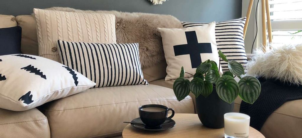 Styled scene with black and white cushions of different prints, textures and sizes