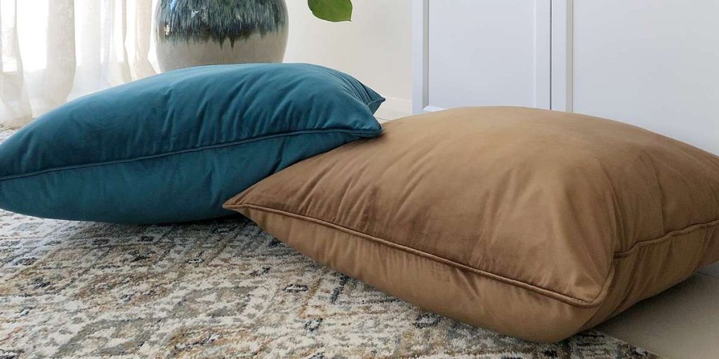 Close up of two velvet floor cushions in blue and brown