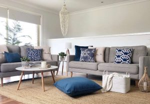 Grey sofa with blue velvet cushions and floor cushion
