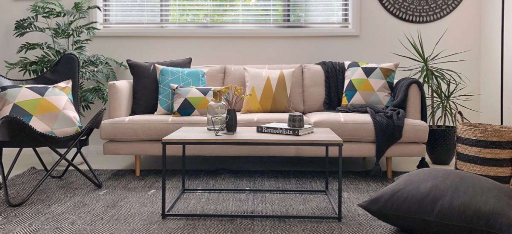 A scene styled with urban modern decor including blue patterned cushions and black chair