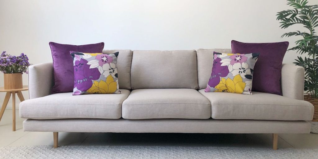 A grey sofa in a living room with a standard 2 2 cushion arrangement
