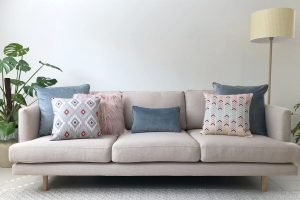 Grey sofa with pastel cushions in pink, grey and blue