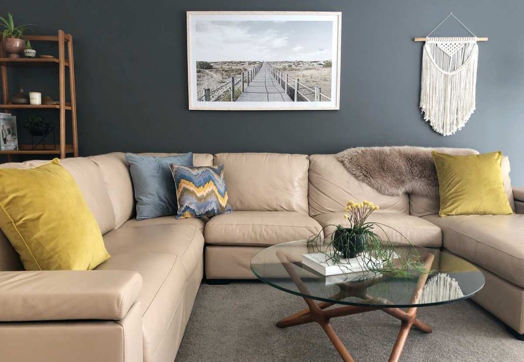 Sofa setting with two large velvet mustard cushions on the outer and 2 cushions in the centre