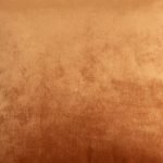 Photo of copper coloured cushion made of velvet fabric