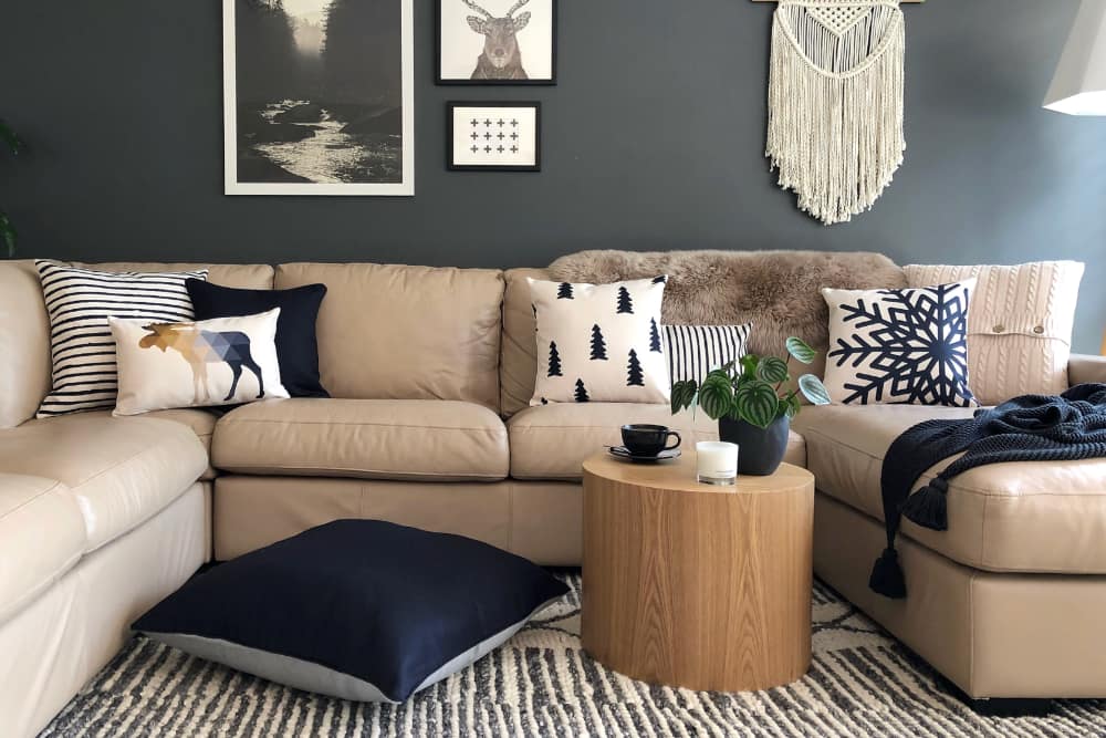 A scandi styled living room scene is shown with large floor pillows in the centre in navy and grey colours