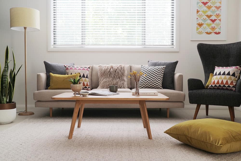 Lovely yellow mustard large floor pillows shown with mustard elements present around other areas of the room