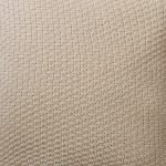 Close up photo of beige cushion cover made of knit fabric