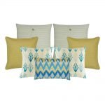 A set of 7 cushions covers with solid, modern floral, cable knit and chevron patterns and in gold and blue colours