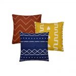 Photo of 3 rust, yellow and navy square cushions in mud cloth print