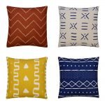 Image of 4 mud cloth cushions in rust, white, yellow and navy colours with mali-inspired prints