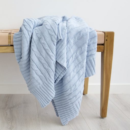 Blue throw blanket tastefully laid out on top of a modern bench chair