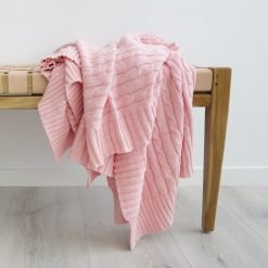 Stunning woven blush pink throw blanket on top of a seat