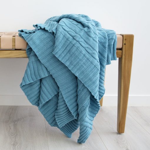 Vivid teal throw blanket that really pops against a grey background