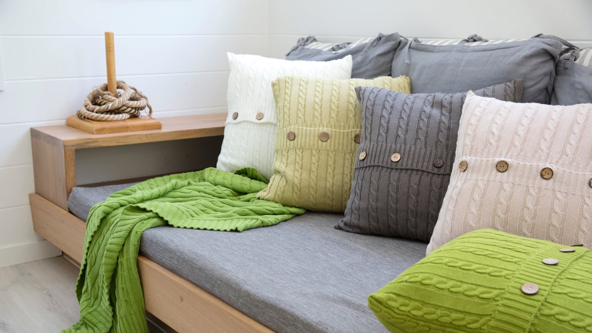 Wonderful Earthy toned knitted couch cushions styled on a grey sofa