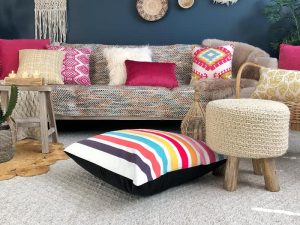 A collection of colourful kids cushions are styled in a room with pink kids pillows and furniture