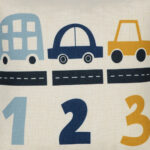Close up photo of little boys cushion with blue and yellow cars