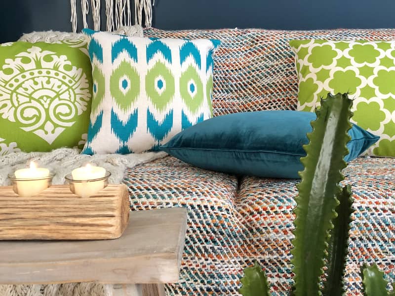 A textured sofa displays a range of green cushions featuring lime green accents