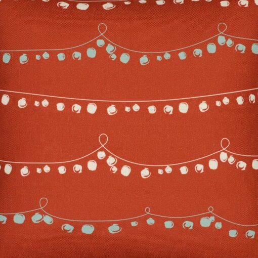Close up photo of red Christmas cushion with a string of baubles