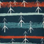Close up photo of vibrant and teal cushion cover with pines and stripes