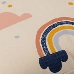 Close up image of large, colourful kids floor cushion cover with rainbows and pink clouds