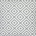 A close up view of a striking geometric pattern is shown on a grey outdoor cushion cover.