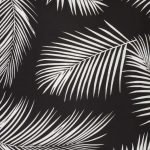A close up view of a repeating palm tree leaf print features on a waterproof black and white outdoor cushion cover.