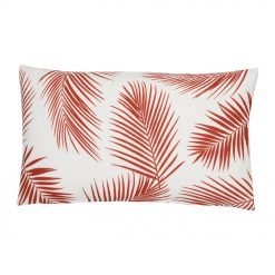 A rectangular red outdoor cushion with beautiful palm leaf pattern on both sides.